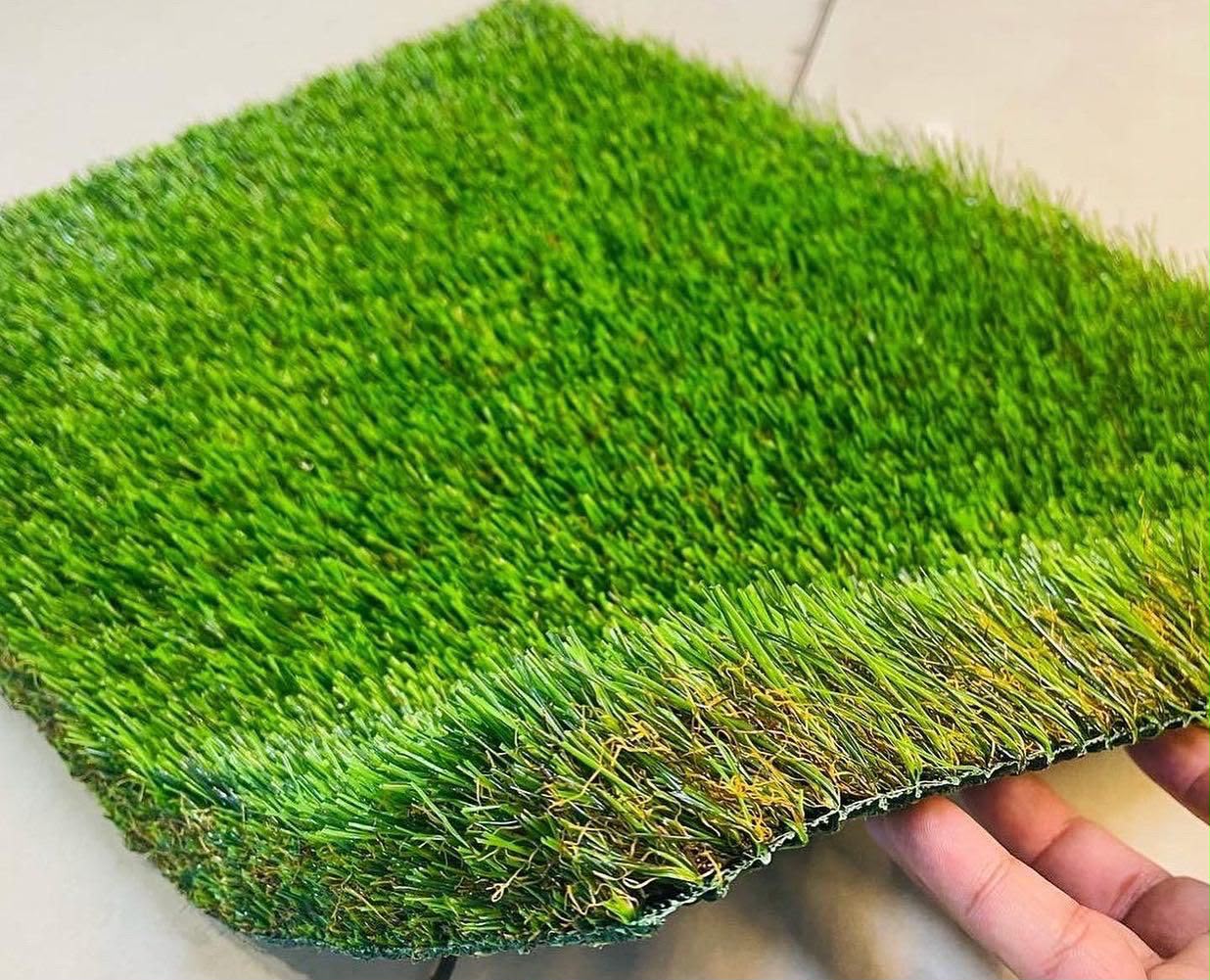 Artificial grass sample showing full green colour and dense turf backing